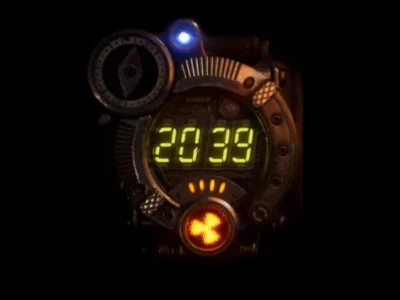 Retro-futuristic device displaying “2039” in glowing green digits, surrounded by industrial metal casing, a compass dial, and small illuminated indicators against a dark background
