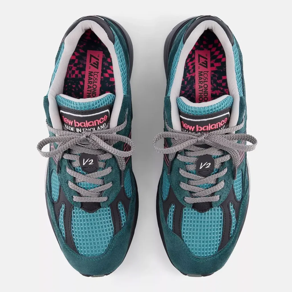 Top-down view of a pair of New Balance shoe, showcasing the full upper construction and interior details. The shoes feature teal suede overlays layered over aqua mesh panels, with grey laces tied across the midfoot and a “V2” lace badge at the center. The tongue displays “new balance Made in England” branding in pink and white, while the inner lining reveals a vibrant patterned insole with London Marathon-themed graphics. The symmetrical layout emphasizes craftsmanship, color contrast, and material depth against a clean, neutral background