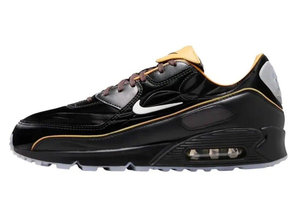 Nike Air Max 90 “Korea” in black premium leather with brown laces, gold-orange piping, sculpted sidewall texture, and visible Air unit in a darkened sole unit