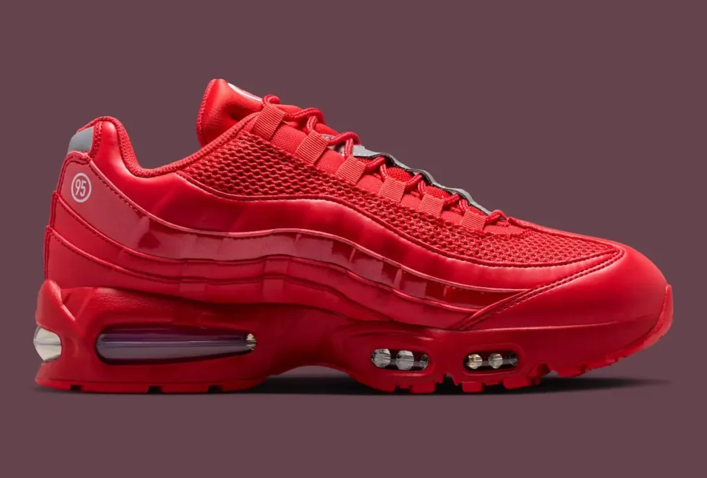 Side profile of Nike Air Max 95 Total 90 “University Red” highlighting monochromatic red upper, layered panel construction, mesh detailing, and visible Air Max cushioning units along the sole