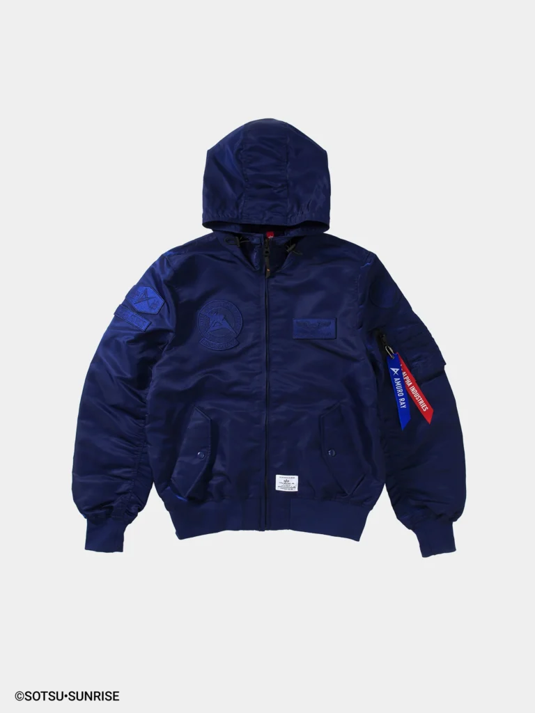 Front view of a navy blue hooded MA-1 style bomber jacket with a smooth, slightly glossy finish and padded structure. The design features tonal embroidered patches on the chest and sleeves, a zip front closure, ribbed cuffs and hem, and a sleeve utility pocket with red “Remove Before Flight” and blue “Amuro Ray” tags, set against a clean white background