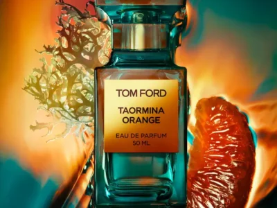 A Tom Ford Taormina Orange Eau de Parfum bottle in translucent teal glass, centered against a vivid gradient backdrop of warm orange and cool aqua tones, accented by a glossy citrus segment and organic coral-like textures, emphasizing the fragrance’s vibrant, Mediterranean-inspired character