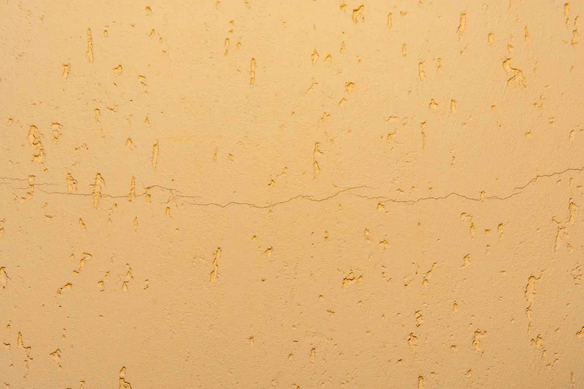 Minimalist illuminated rectangular light panel suspended against a dark wall, casting a soft glow around its frame