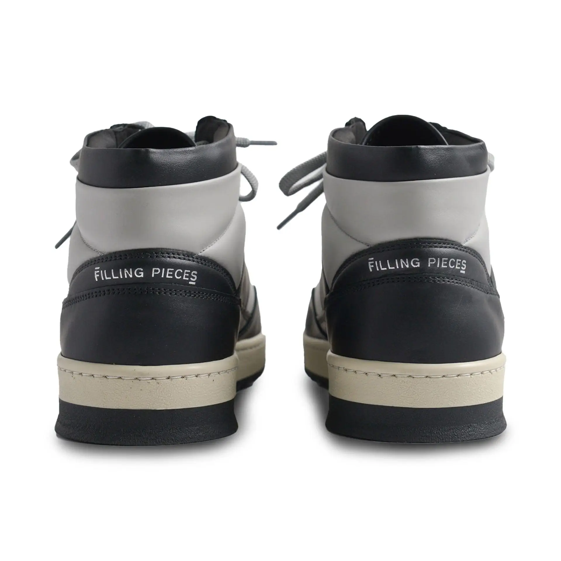 Rear view of two black and grey leather Filling Pieces sneakers showing heel panels with logo branding, layered midsole construction, and clean minimalist design against a light background