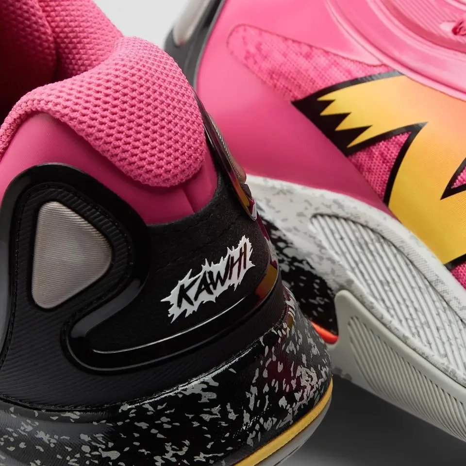 Close-up of New Balance KAWHI V in pink and black colorway showing textured collar, speckled midsole, and “Kawhi” heel branding detail