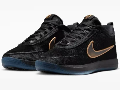 Pair of black furry Nike sneakers photographed in three-quarter perspective, emphasizing the luxurious pony hair construction, bronze accents, and icy blue outsole finish