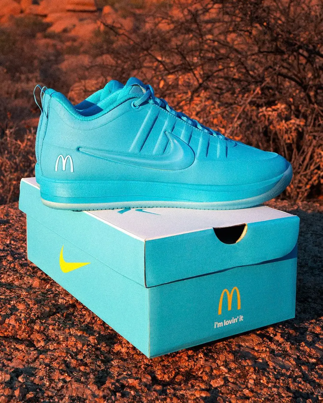 Turquoise McDonald’s x Nike Book 2 special edition displayed atop a co-branded shoebox in a desert setting, featuring monochromatic styling inspired by Sedona’s iconic turquoise arches