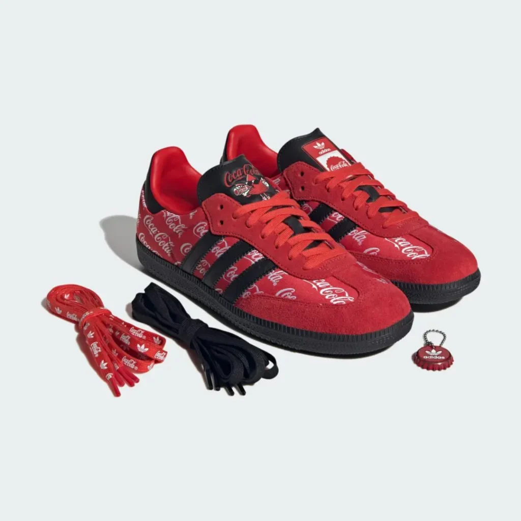 Coca-Cola x adidas Samba OG “Red/Black” shoe displayed with extra laces and branded bottle cap accessory featuring red suede overlays, Coca-Cola script graphics, and black Three Stripes detail