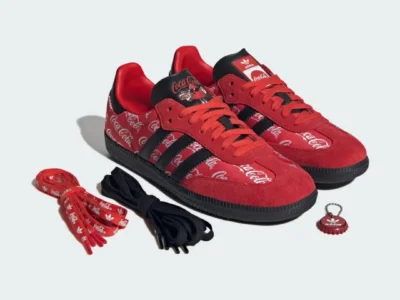 Coca-Cola x adidas Samba OG “Red/Black” shoe displayed with extra laces and branded bottle cap accessory featuring red suede overlays, Coca-Cola script graphics, and black Three Stripes detail