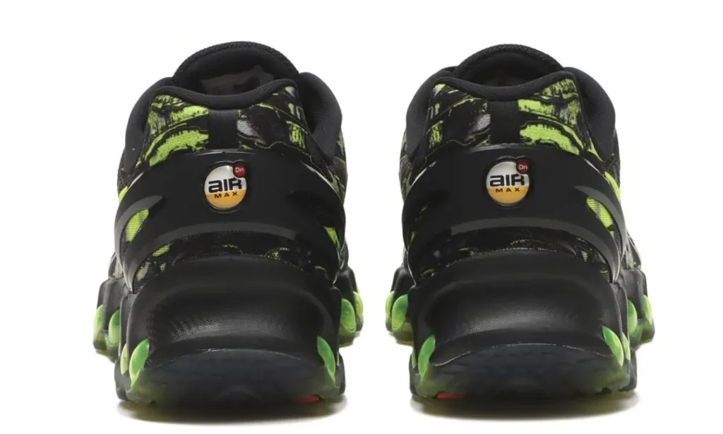 Rear view of the Nike Air Max DN8 “Black/Green Apple” showing the sculpted black heel structure, circular Air Max heel badges, neon green marbled upper detailing, and translucent green Dynamic Air pods visible around the heel and outsole for a futuristic cushioning look
