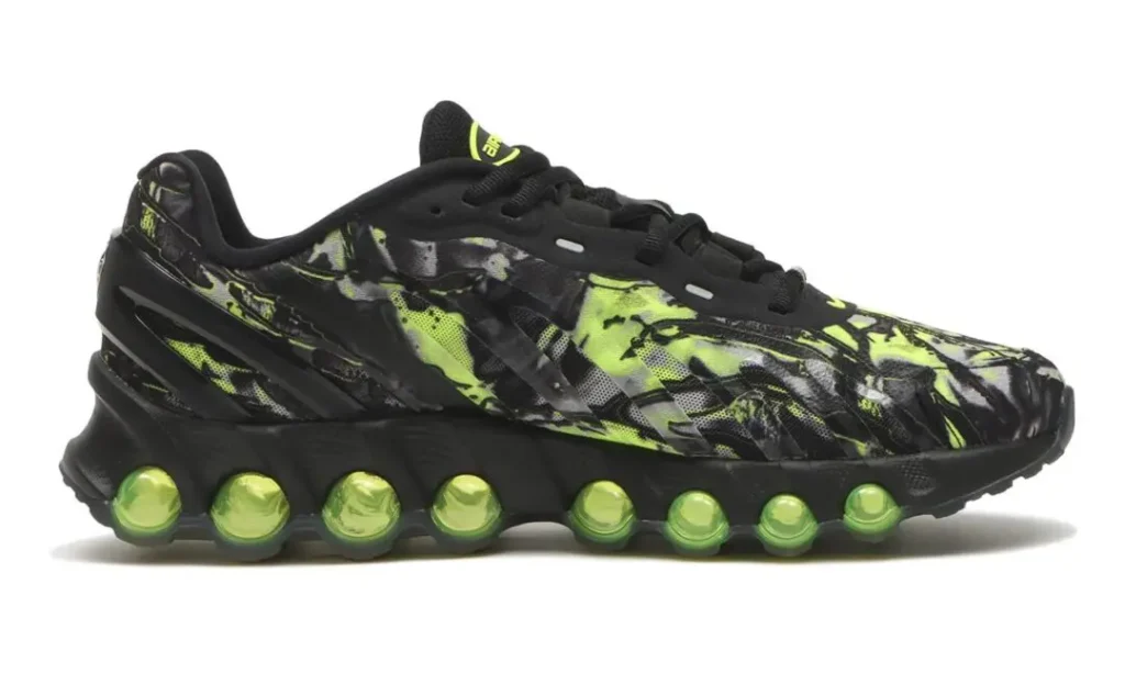Side profile of the Nike Air Max DN8 “Black/Green Apple” featuring a black mesh and synthetic upper layered with abstract neon green marbled graphics, tonal black overlays, and a full-length row of translucent green Dynamic Air pods integrated into the sculpted black midsole