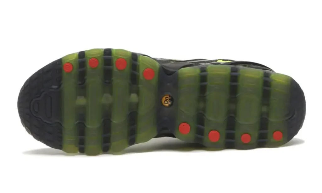 Outsole view of the Nike Air Max DN8 “Black/Green Apple” showcasing the full-length translucent green Dynamic Air tube system, black traction channels, and contrasting red circular traction accents across the sole for a futuristic performance-driven finish