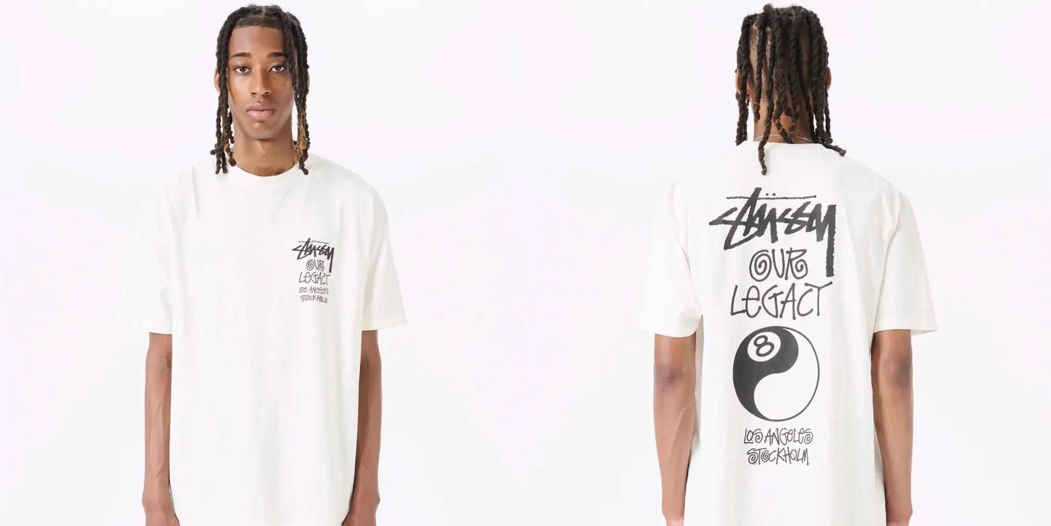 Front-and-back studio product view of an oversized off-white graphic T-shirt worn by a model against a clean light background. The front features a small handwritten-style chest graphic reading “Stüssy Our Legacy” with Los Angeles and Stockholm text beneath. The back expands the same collaborative artwork in oversized black print with a large yin-yang style 8-ball graphic and stacked handwritten typography