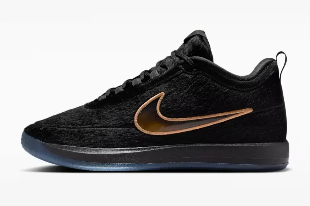 Lateral side profile of the black low-top Nike sneaker with hairy suede-like texture, metallic bronze Swoosh embroidery, black foam midsole, and translucent outsole detailing