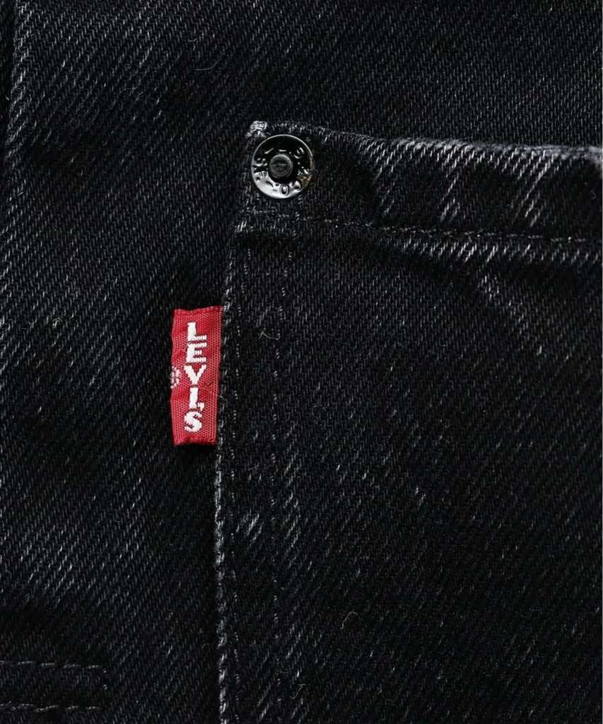 Close-up of the signature red Levi’s tab integrated into the oversized pocket design of the ÉDIFICE collision jacket