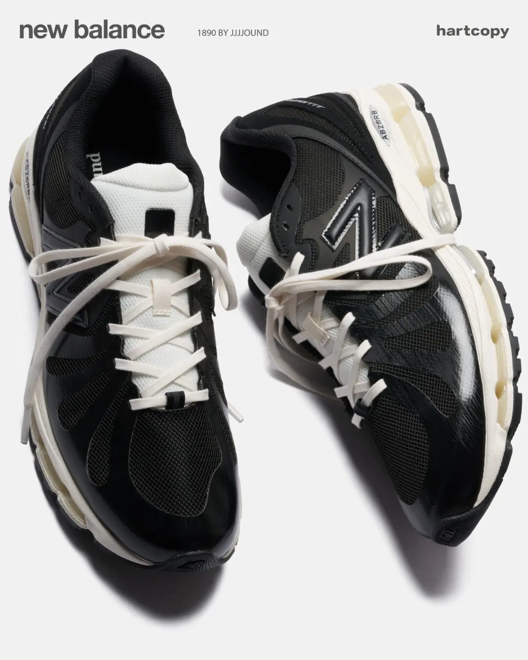 Editorial product image of black and cream New Balance 1890 by JJJJound sneakers featuring glossy black overlays, breathable mesh panels, oversized white laces, and translucent ABZORB cushioning pods against a light gray studio background