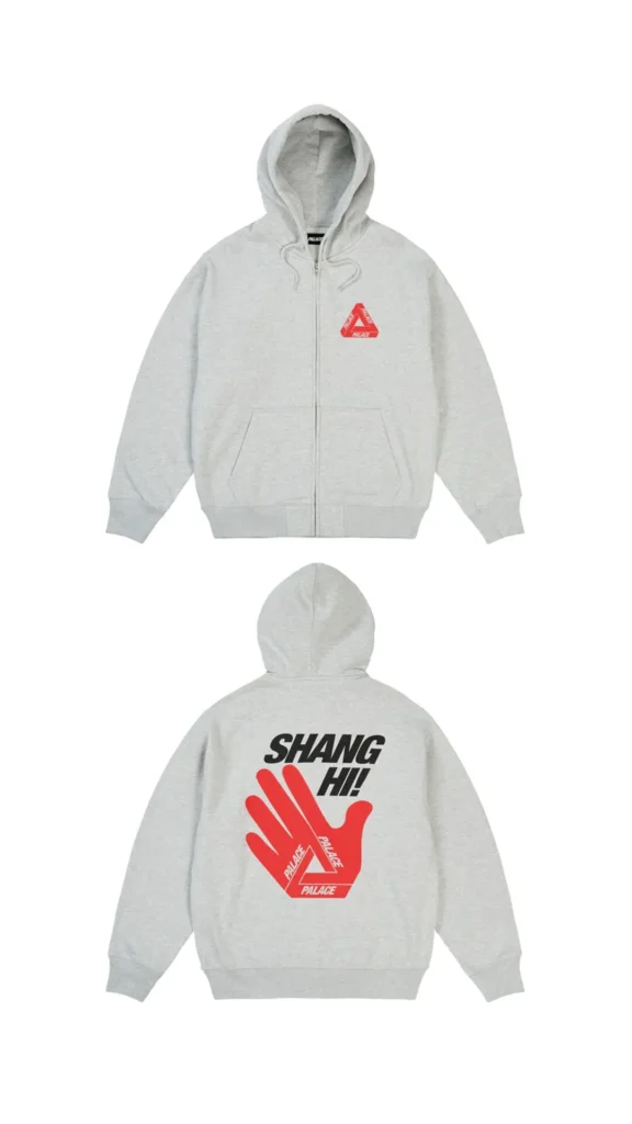 Front and back views of a heather grey Palace zip-up hoodie featuring a small red Tri-Ferg logo on the chest and a large back graphic with bold black “SHANG HI!” typography above a red hand illustration forming the iconic Palace triangle logo, released as part of the Shanghai flagship opening collection