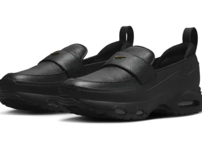 Nike Air Max Phenomena Triple Black loafers shown in an angled front view, featuring textured black leather uppers, gold mini Swoosh accents, and oversized Air Max-inspired platform soles