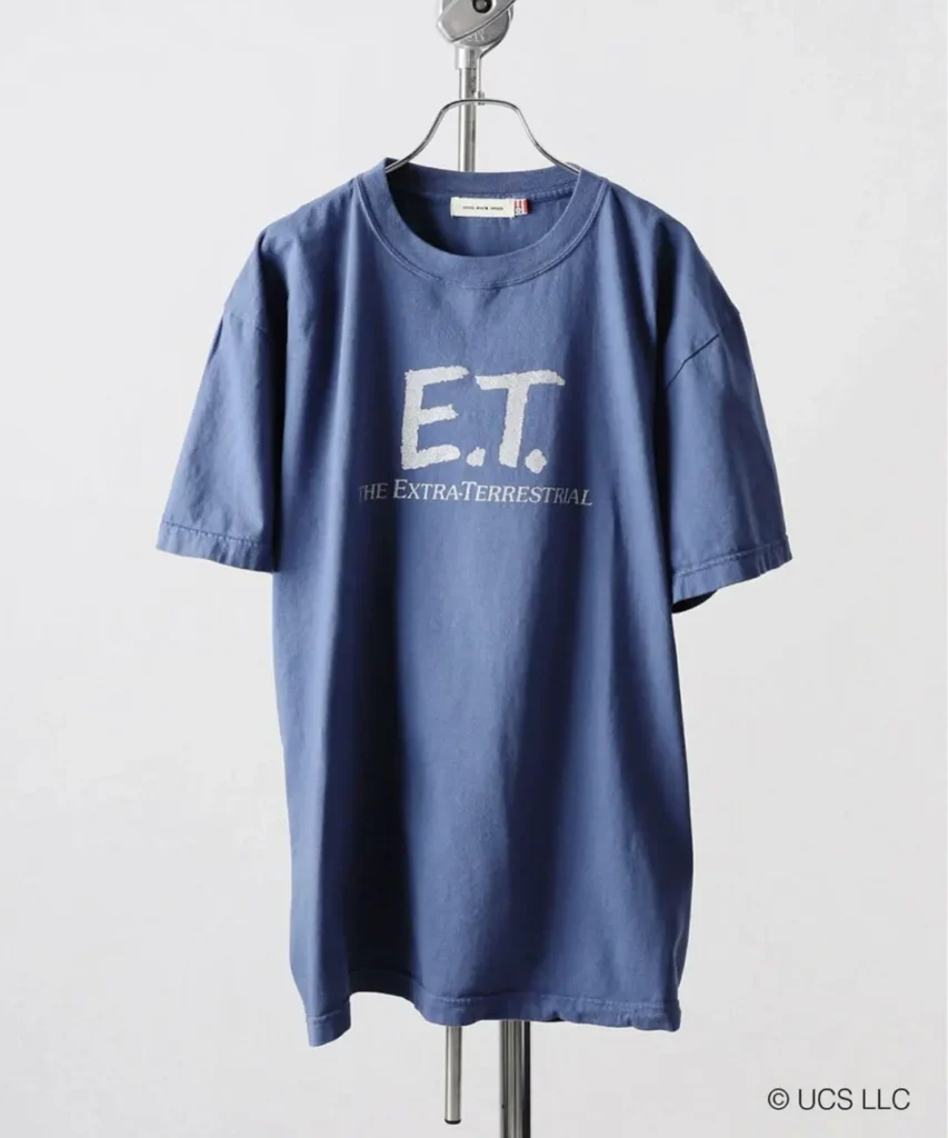 Washed blue B.C STOCK × GOOD ROCK SPEED E.T. graphic T-shirt featuring minimalist white “E.T. The Extra-Terrestrial” typography across the chest with vintage-inspired fade