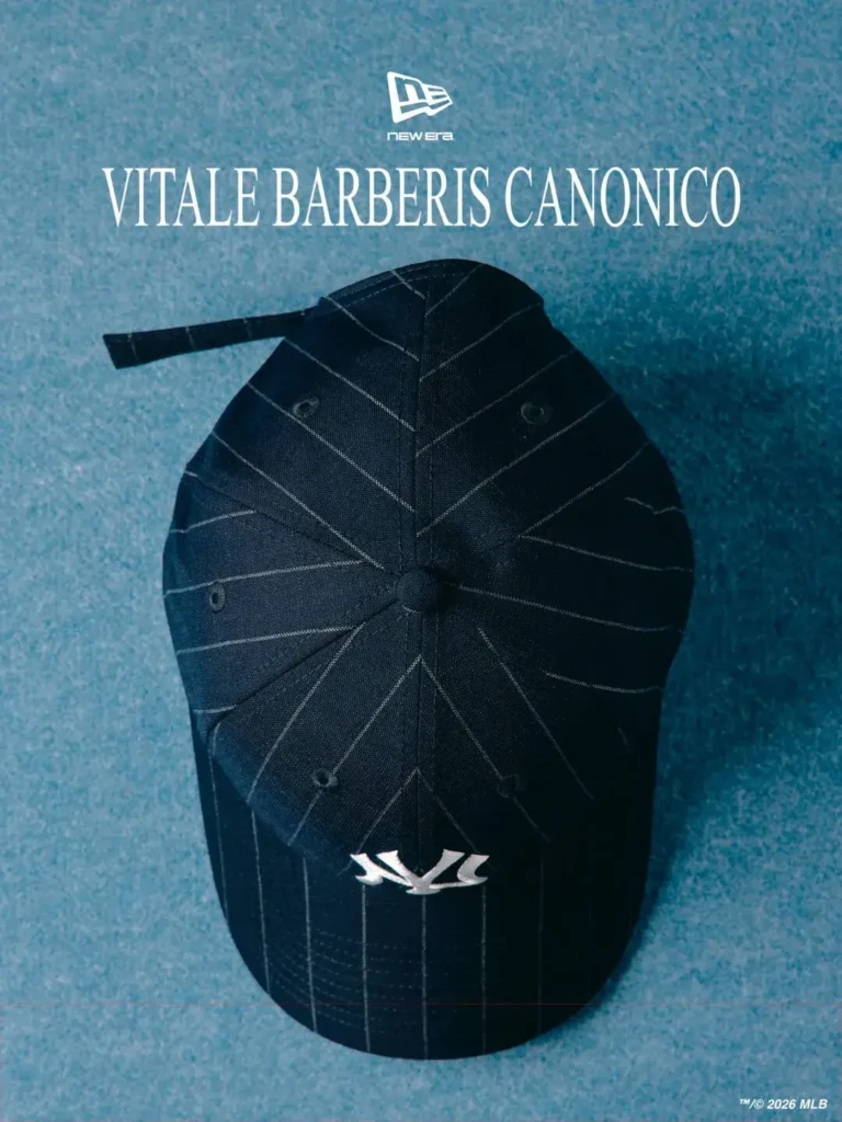 Top-down view of a dark navy New Era 9FORTY cap featuring refined white pinstripe tailoring details radiating across the panel construction and curved brim. Positioned beneath bold “Vitale Barberis Canonico” branding on a textured blue backdrop, the image highlights the cap’s premium Italian wool composition and understated Yankees embroidery near the visor edge