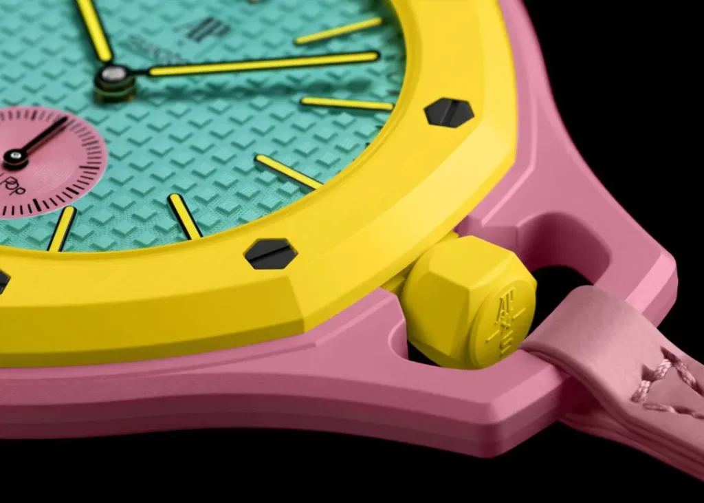 An ultra-close macro shot of a colorful octagonal wristwatch featuring a pastel pink case, bright yellow bezel and crown, and a turquoise textured dial with contrasting pink subdial details against a deep black backdrop