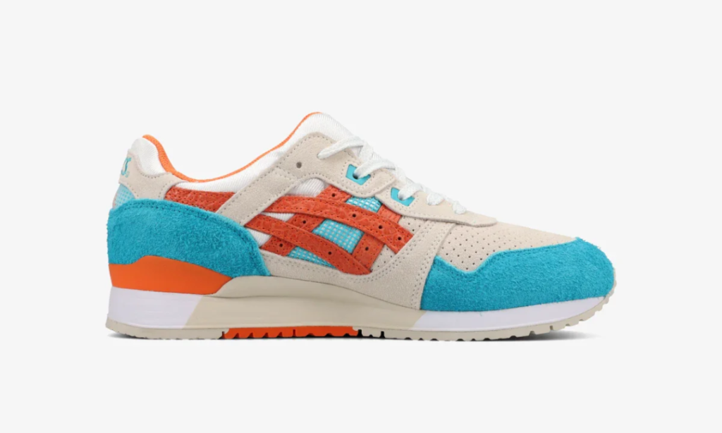 Side profile of the ASICS GEL-LYTE III sneaker in cream suede with vibrant turquoise hairy suede mudguards and heel panels, burnt orange ASICS stripes, aqua mesh underlays, white laces, and an off-white midsole with orange outsole accents against a light gray backdrop