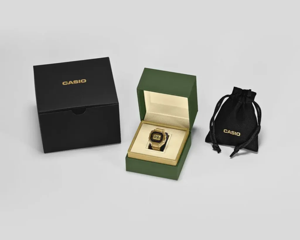 Casio CRW-001G-9JR ring watch packaging set featuring the gold digital ring watch inside a presentation box alongside branded storage accessories.