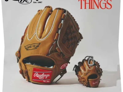 Editorial product campaign image for Rawlings “Baseball Things” featuring a full-size tan leather baseball glove beside a miniature glove keychain accessory, highlighting heritage stitching, woven detailing, and vintage athletic branding against a clean studio backdrop