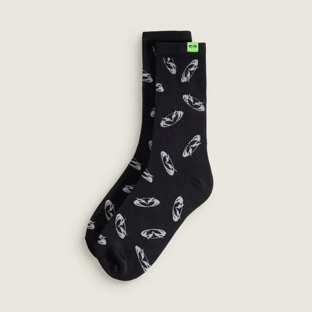 Black Vans x GUCCIMAZE crew socks covered in repeating custom logo graphics, blending skate functionality with contemporary streetwear design
