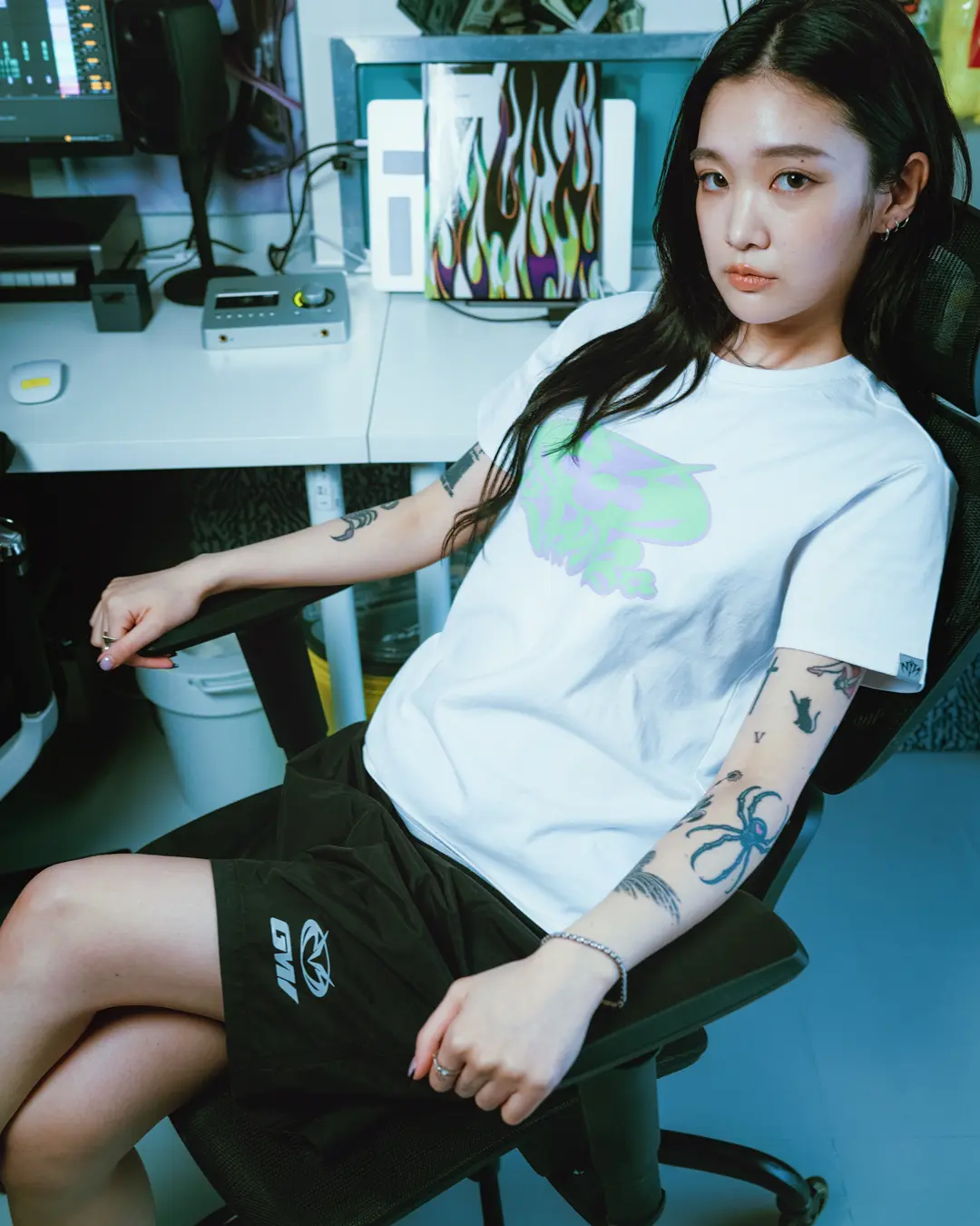 Lifestyle portrait featuring a model in the Vans x GUCCIMAZE collection, wearing a white graphic T-shirt and black shorts accented with the artist’s custom brand