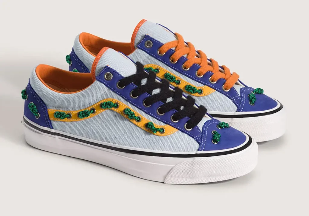 Rear view of the OTW by Vans Old Skool 36 “Knot” in the Royal Cobalt / Multi Blue colorway, highlighting cobalt suede heel panels threaded with green nautical rope knots through metal eyelets. The design is finished with light blue heavyweight canvas, bright orange lining, elevated white foxing, and OTW skateboard branding printed on the heel