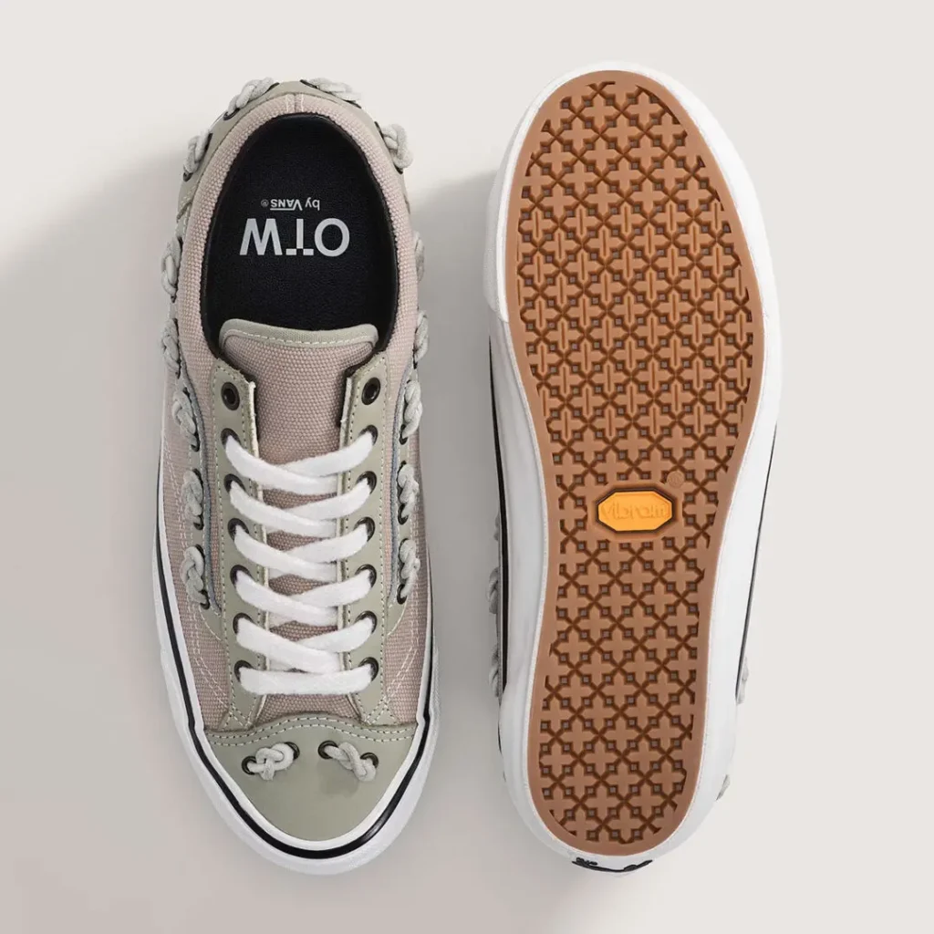 Top and outsole view of the OTW by Vans Old Skool 36 “Knot” in the Soft Sage / Mushroom Brown colorway, featuring textured heavyweight canvas, muted sage suede overlays, oversized fuzzy white laces, and rope-style knot detailing integrated along the side stripe and toe. The interior shows OTW by Vans branding on a dark footbed, while the reverse reveals a gum Vibram outsole with a geometric traction pattern for upgraded grip and day show