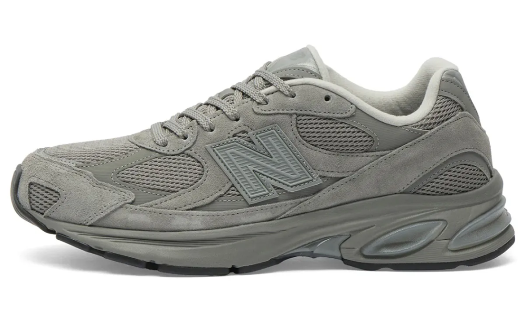 The lateral profile of the New Balance U2010 3EJ “Harbor Grey” highlights the silhouette’s streamlined interpretation of early-2000s running design, pairing layered suede overlays with breathable mesh underlays in a fully monochromatic grey palette. The oversized tonal “N” logo sits at the center of the upper, while the sculpted ABZORB midsole introduces a futuristic cushioning aesthetic through its pod-like detailing and curved geometry. The combination of muted textures, technical paneling, and chunky proportions gives the shoe a refined balance between retro performance heritage and modern lifestyle minimalism
