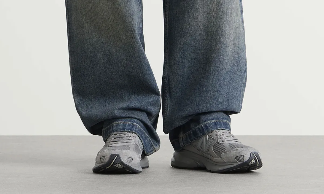 An on-foot view of the New Balance U2010 3EJ “Harbor Grey” shows how naturally the silhouette integrates into relaxed everyday styling, paired here with loose-washed denim that complements the shoe muted tonal palette. The chunky ABZORB sole unit adds subtle height and sculptural presence beneath the wide-leg fit, while the layered grey mesh and suede upper reinforces the understated “quiet luxury” appeal that defines New Balance’s contemporary lifestyle direction. The overall look balances retro running influence with effortless modern wearability, emphasizing comfort without sacrificing refinement