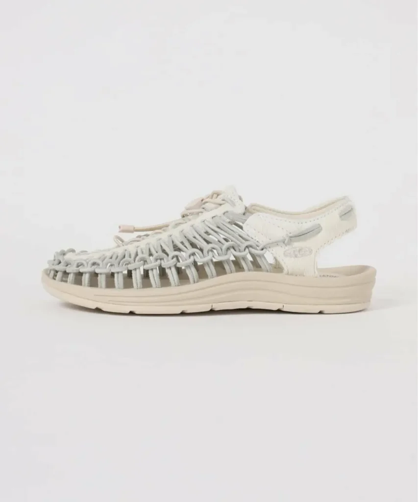 Medial side profile of a cream and light grey KEEN open-heel sandal highlighting the signature woven rope upper, textured leather heel panel, bungee lace system, and layered ergonomic sole