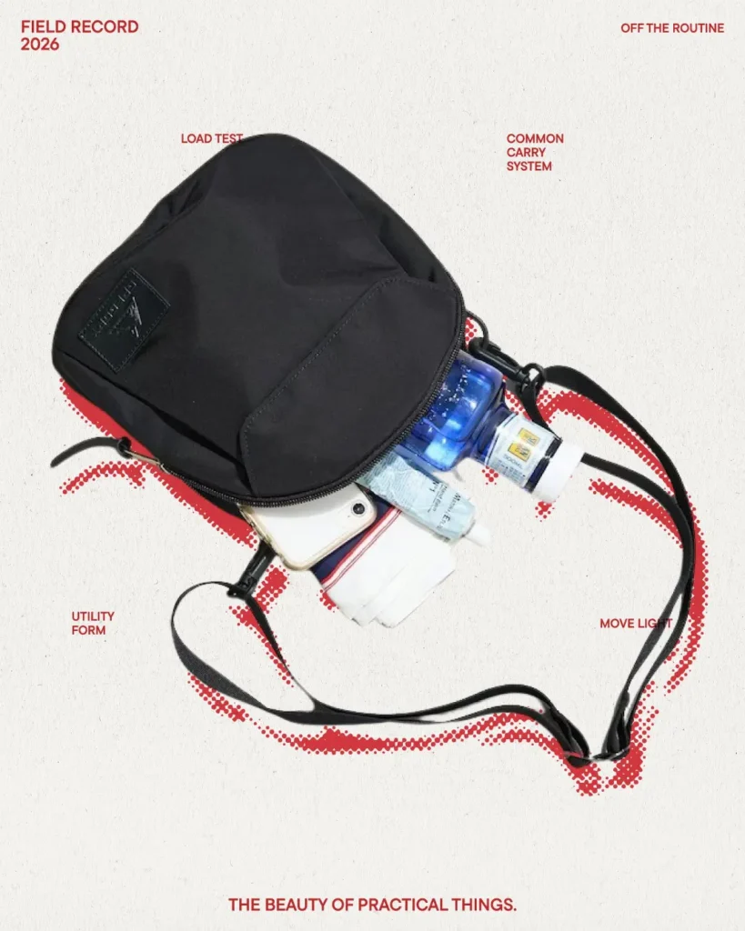 Black GREGORY crossbody bag shown open with travel essentials and everyday carry items highlighting compact storage capacity