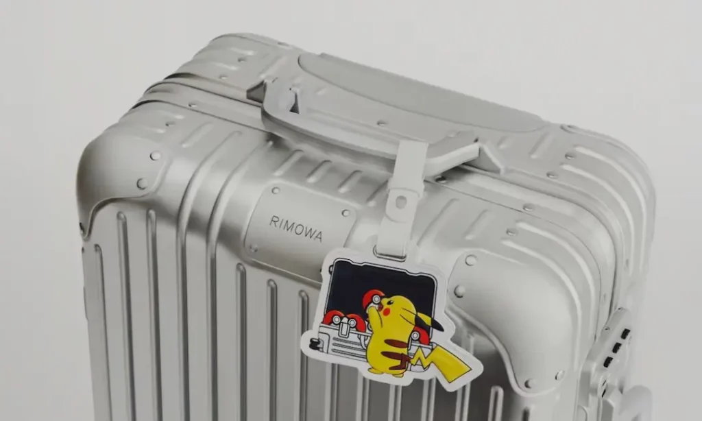 Silver RIMOWA aluminum suitcase customized with a premium Pikachu leather luggage charm, blending luxury travel design with classic Pokémon nostalgia