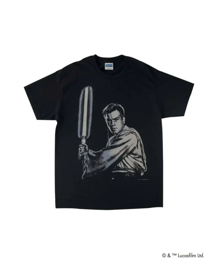 Black VARIEGATOR graphic T-shirt featuring a monochrome portrait of Obi-Wan Kenobi holding a lightsaber in retro movie-poster style artwork