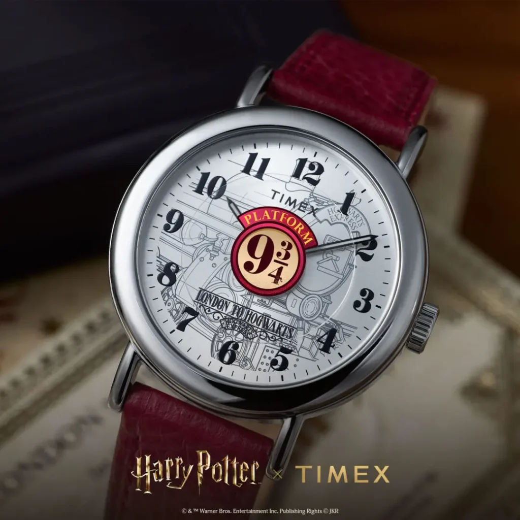 Close-up campaign image of the Timex x Harry Potter and the Philosopher's Stone Platform 9¾ watch featuring a silver-toned dial with illustrated Hogwarts Express artwork, oversized Platform 9¾ centerpiece graphic, vintage-style black numeral markers, polished silver-tone case, and burgundy leather strap styled against warm archival-inspired textures