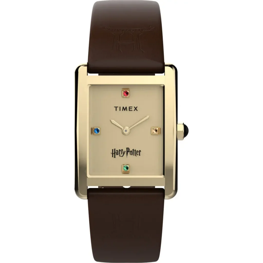 Studio product image of the Timex x Harry Potter and the Philosopher's Stone Hailey Hogwarts watch featuring a rectangular gold-tone case, brushed champagne dial, minimalist gold hands, four house-colored crystal hour markers, and dark brown leather strap embossed with Hogwarts-inspired “H” detailing against a clean gray background