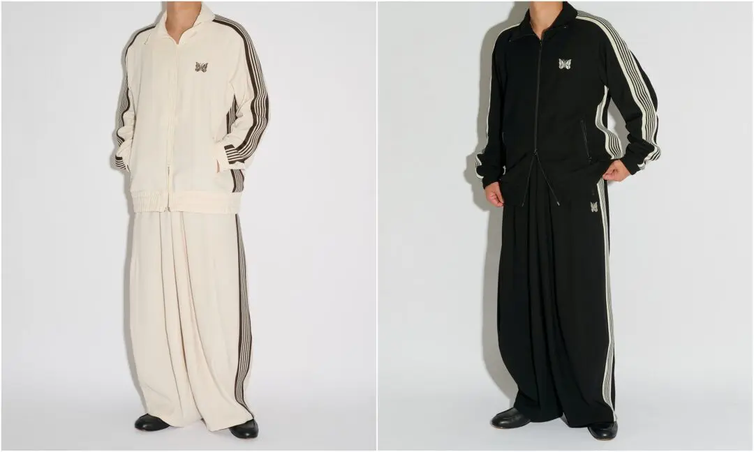 Two full NEEDLES x STUDIOUS Amunzen tracksuit looks shown side by side, featuring the oversized Track Jacket and dramatically voluminous H.D. Track Pant silhouette in Ecru White and Black with contrasting side stripes and signature butterfly embroid