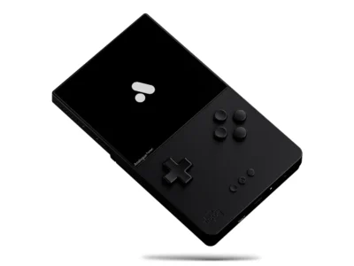 Floating black Analogue Pocket Aluminum handheld console rendered against a clean light-gray background, showcasing its CNC-machined all-metal enclosure, monochromatic button layout, sharp rectangular display, and minimalist industrial design language that reinterprets the classic Game Boy silhouette through a luxury hardware aesthetic