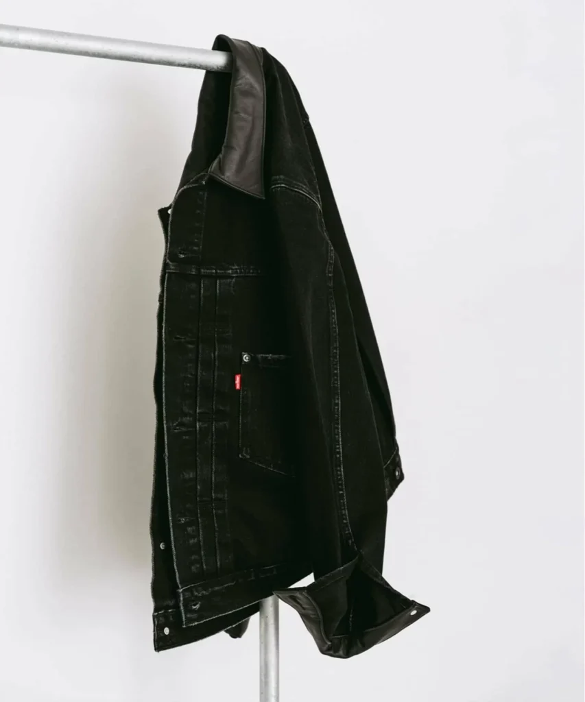 Side profile of the ÉDIFICE x Levi’s black Type II jacket featuring a structured leather collar, washed black denim, and heritage-inspired workwear detail
