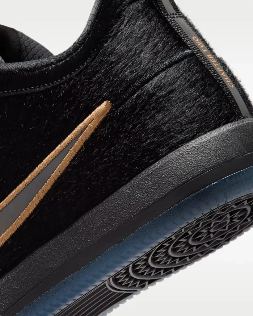 Close-up detail of the black pony hair sneaker upper featuring a bronze outlined Nike Swoosh, textured black midsole, and translucent icy outsole edge with “CHAPTER TWO” heel tab branding