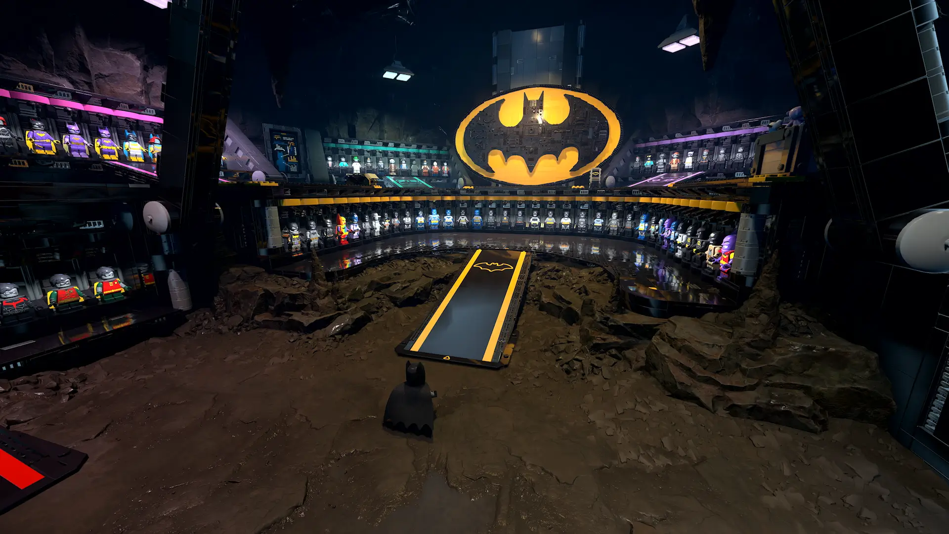 A massive LEGO Batcave interior showcases rows of Batman suits, glowing tech displays, rocky cavern walls, and a large illuminated Bat-symbol above the central platform