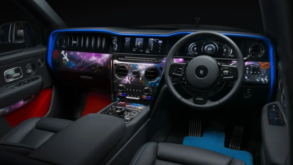 Luxurious Rolls-Royce interior illuminated by deep blue ambient lighting, featuring custom cosmic-inspired dashboard artwork with neon stars, planets, abstract symbols, and galaxy-like graphics layered across the cabin’s glossy trim panels