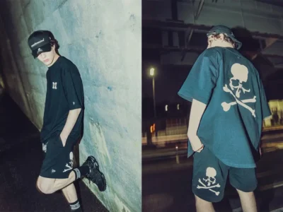 Editorial campaign diptych showing a model wearing pieces from the New Era® × mastermind JAPAN collection at night beneath an urban overpass. On the left, the model leans against a concrete wall in an oversized black tee, black shorts with skull-and-crossbones graphics, black sneakers, and a co-branded cap. On the right, the back view highlights an oversized skull motif across the shirt and matching graphic shorts, reinforcing the collection’s dark luxury streetwear aesthetic