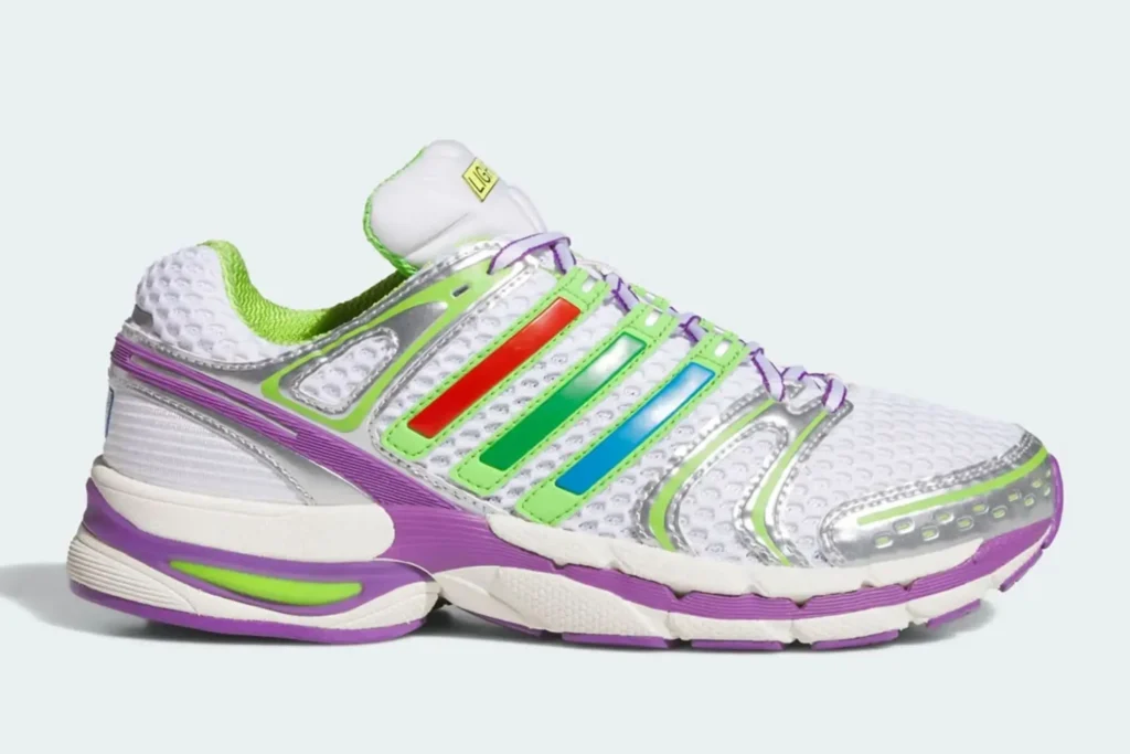 This futuristic adidas runner pairs breathable white mesh with metallic silver overlays and vivid neon accents in green, purple, red, and blue. The layered Three Stripes branding and sculpted midsole give the shoe a distinctly early-2000s performance aesthetic, while the bright palette pushes it into playful, almost toy-like territory. The result feels like a retro tech runner reimagined through a colorful Y2K lens