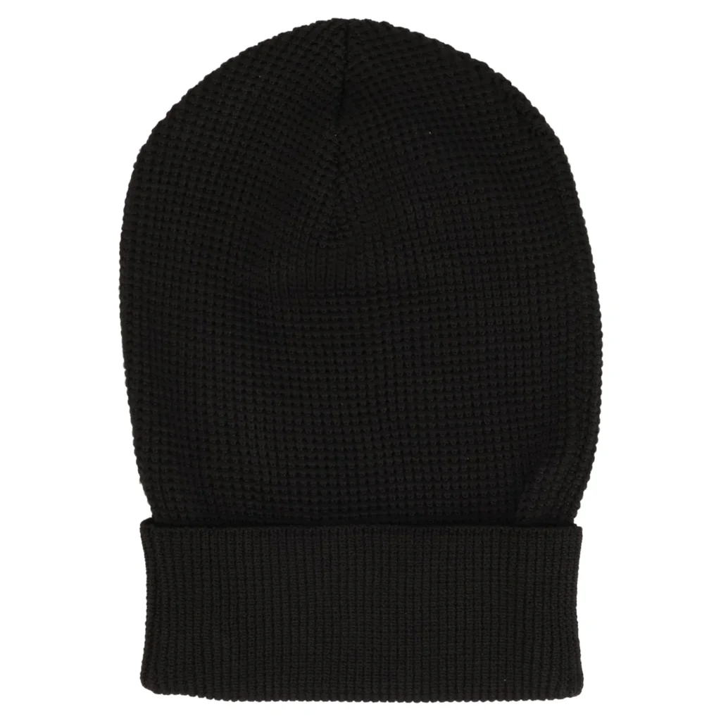 Rear view of the Ashley Williams Knit Skull Beanie in black, shown in a clean product presentation against a light background. The beanie features a chunky textured knit body with visible vertical shaping and a wide folded ribbed cuff. Without visible graphics on the reverse, the design highlights the accessory’s minimal silhouette, soft structure, and understated finish