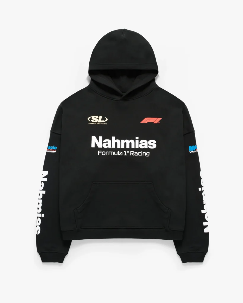 Black pullover hoodie with a structured, slightly oversized fit and a classic kangaroo pocket. The front features bold white “Nahmias” lettering over “Formula 1® Racing,” flanked by a red Formula 1 logo on the right chest and an “SL Summerland Racing” graphic on the left. Additional sponsor-style details appear on the sleeves, including racing-inspired patches and vertical “Nahmias” branding, reinforcing the motorsport aesthetic. Ribbed cuffs and hem complete the silhouette, while the layered graphics give the piece a full race-team jersey feel translated into elevated streetwear